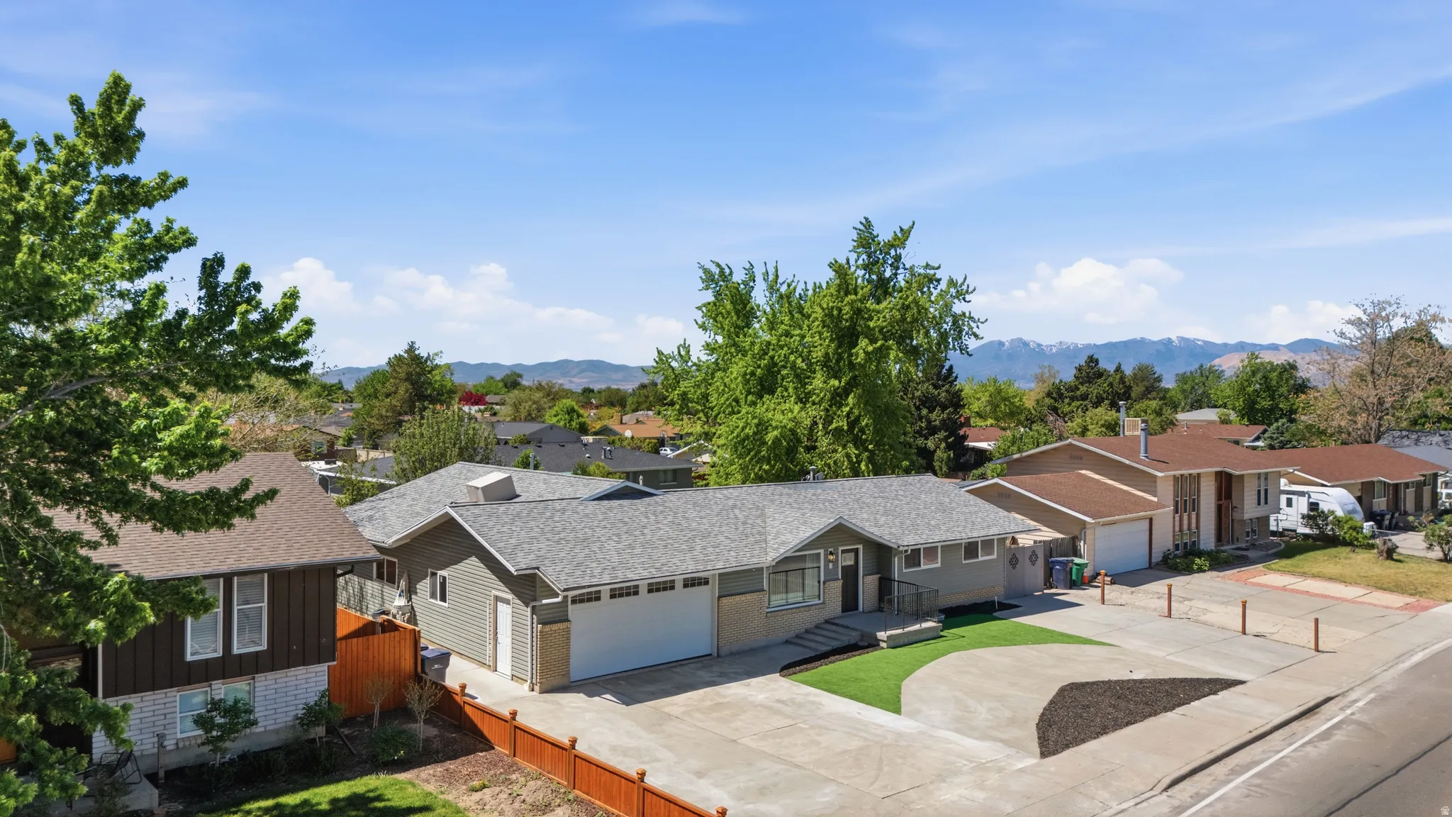 Ranch-style residence featuring a gray exterior, attached two-car garage, and a concrete driveway