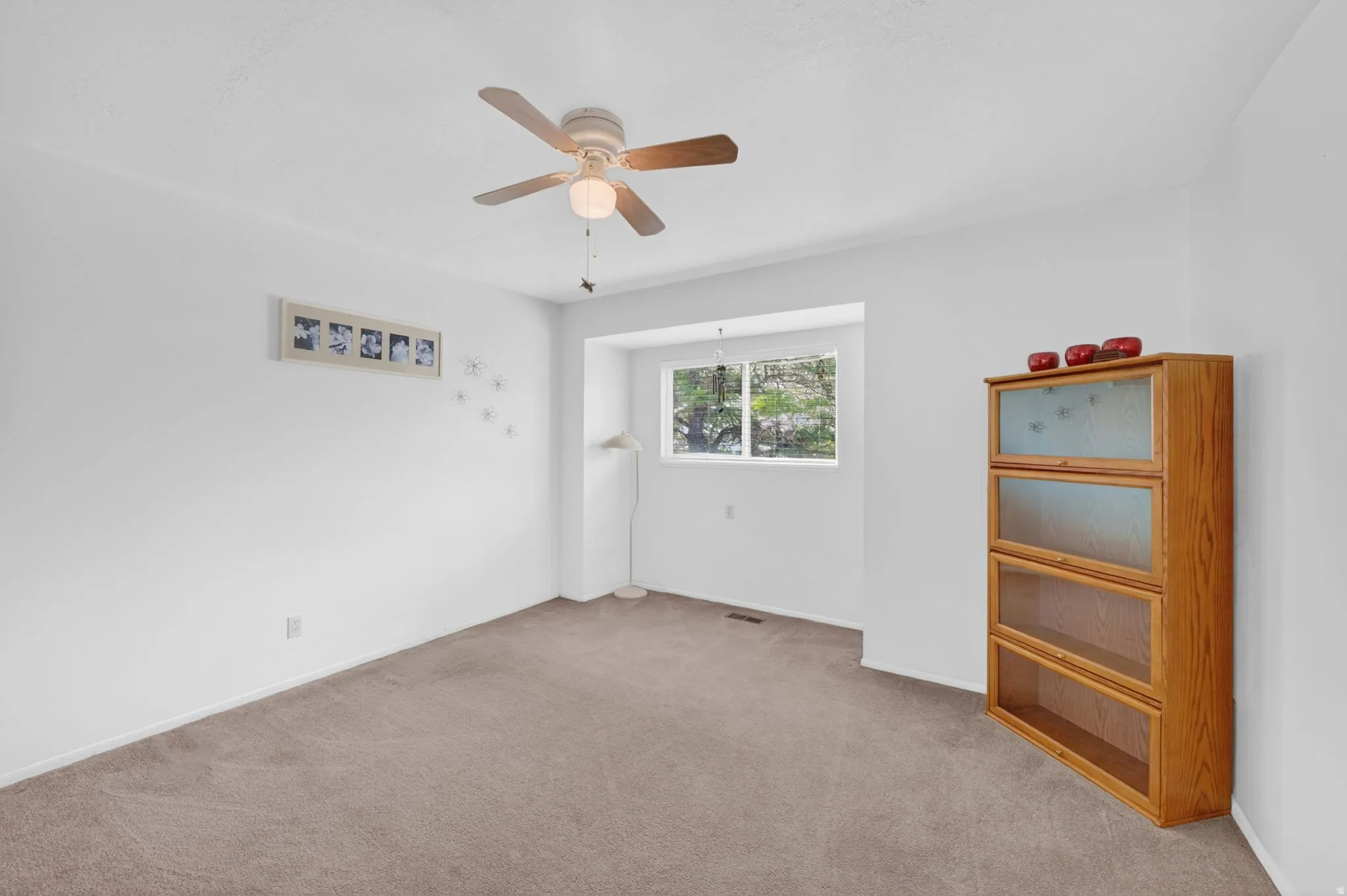 Carpeted interior space with a ceiling fan light fixture