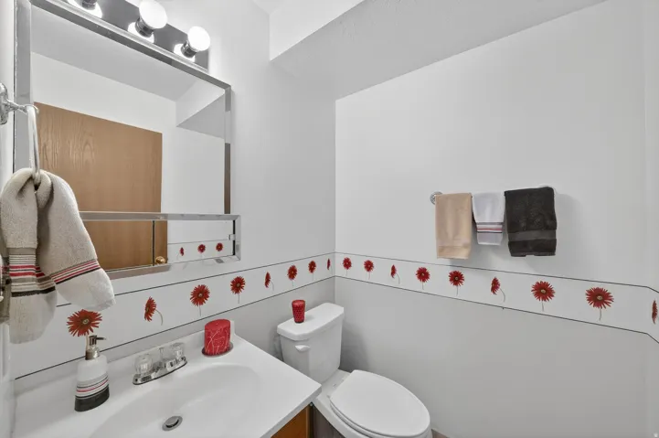 Bathroom vanity with an integrated white sink, dual-handle faucet, and wood-finish cabinetry