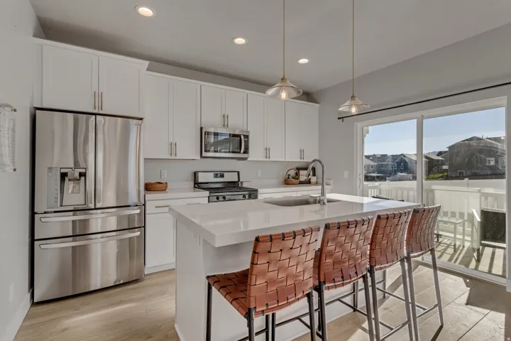 Modern kitchen featuring white cabinetry, stainless steel appliances, a center island with countertop seating, recessed lighting, and wood-finish flooring