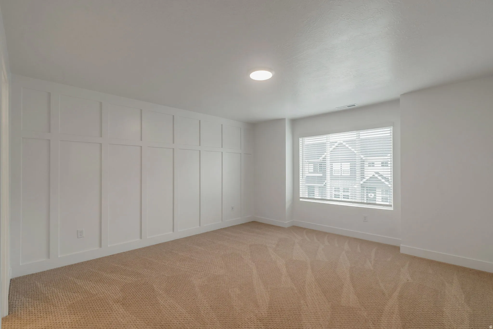 Neutral tone carpeting and recessed ceiling lighting