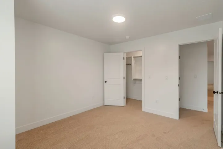 Neutral-toned carpet flooring with white baseboards and walls