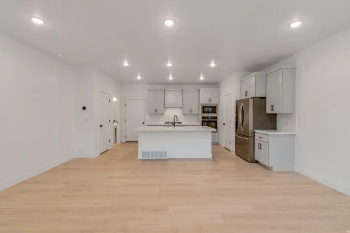 Open-concept living space featuring wood-finish flooring, recessed lighting, and a contemporary kitchen