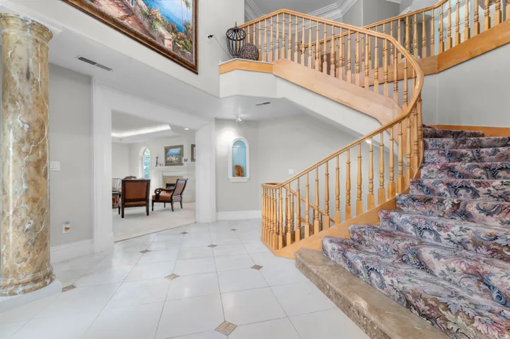 Grand entry featuring a curved wooden staircase with ornate balusters