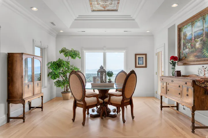 Dining area featuring a coffered ceiling with a stained glass insert, perimeter recessed lighting, and large windows