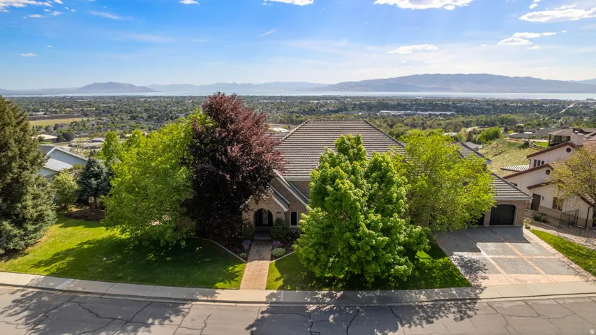 Expansive front yard with a landscaped lawn and mature trees