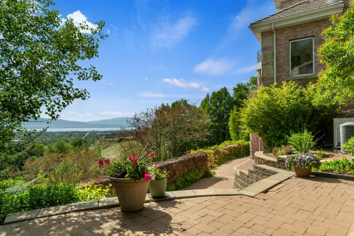Expansive outdoor patio area featuring brick paver flooring and a stone retaining wall