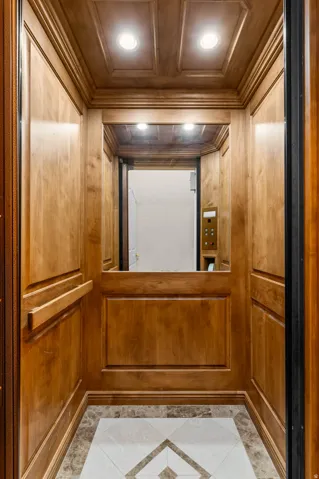 Wood-paneled private elevator with recessed lighting.  Located on all floors