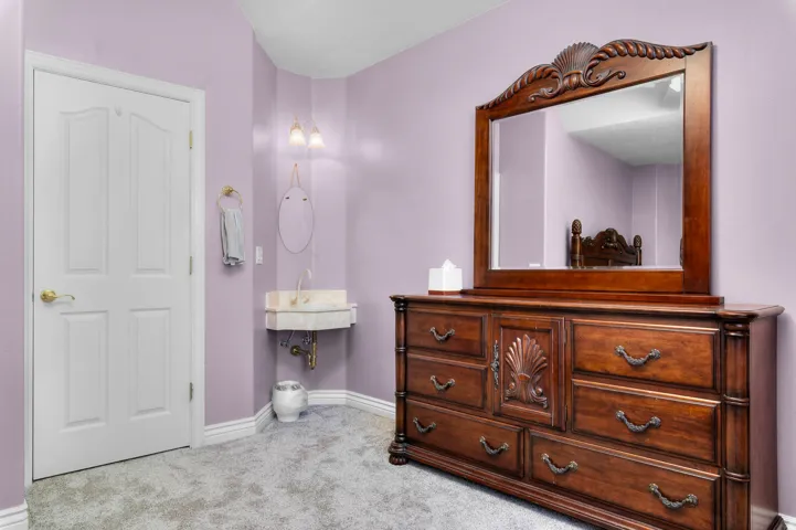 Powder room vanity with a stone basin sink, dual wall-mounted sconces, and a decorative mirror