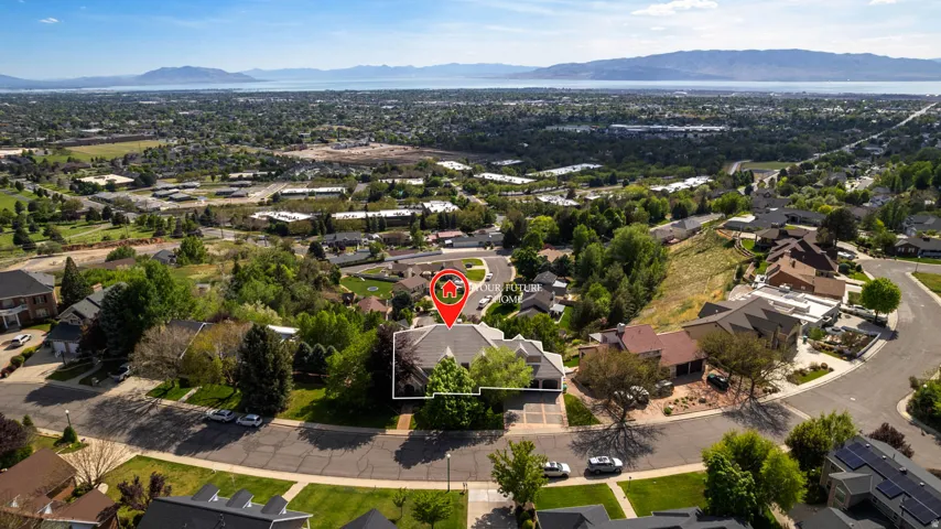 Aerial perspective showcasing a single-family home with a prominent gabled roof and mature tree landscaping