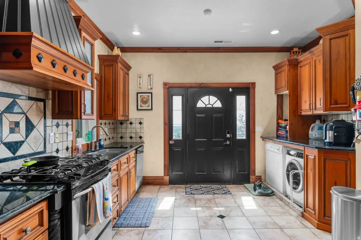 Kitchen featuring a black gas range, built-in black dishwasher, and stainless steel sink with a gooseneck faucet
