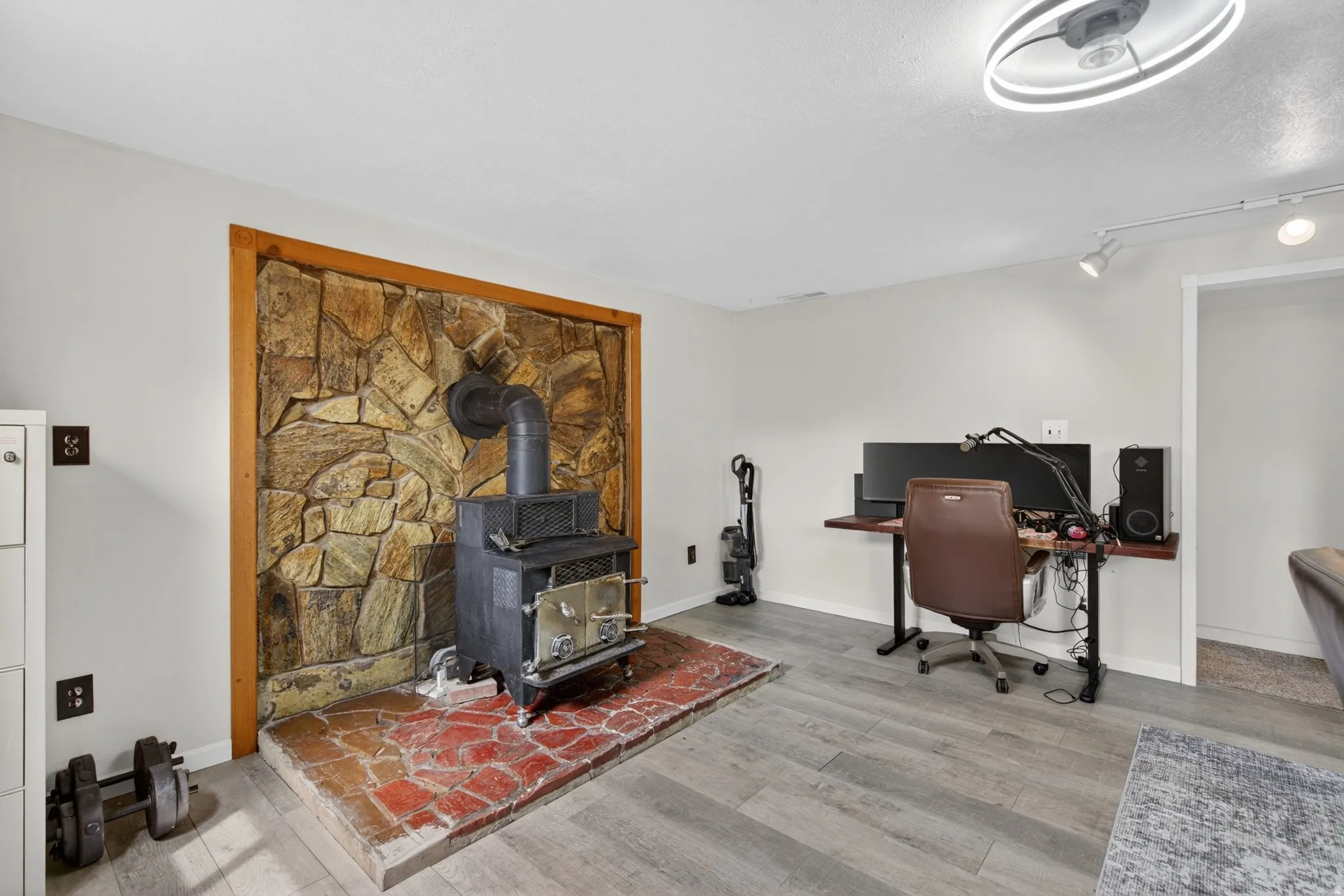 Wood-burning stove set against a natural stone wall, framed by light wood trim