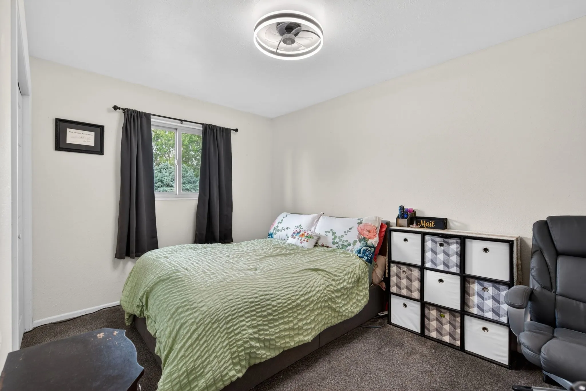 Interior room featuring light-colored walls and dark carpet flooring