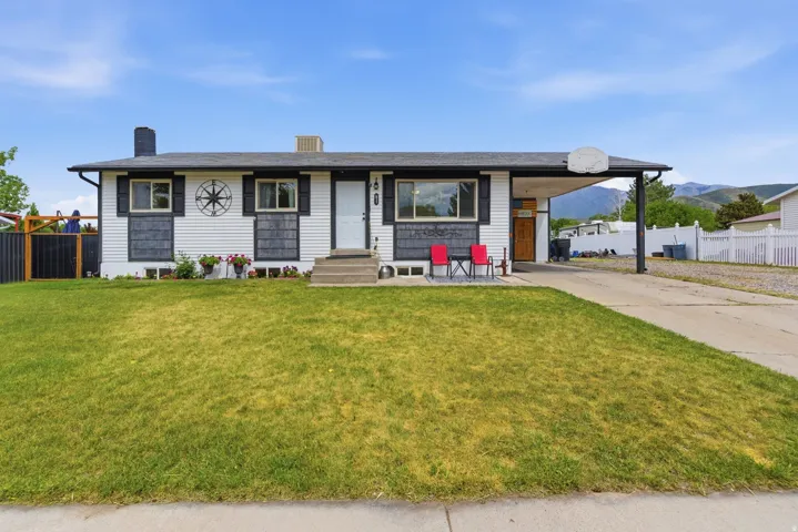 Ranch-style exterior with white siding, dark shutters, and a covered carport