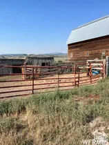 Large wood barn with a metal roof and an extensive fenced enclosure