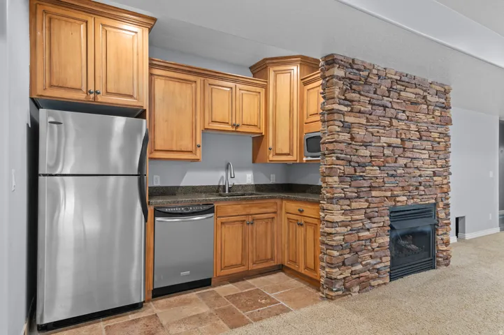 Compact kitchen area featuring wood cabinetry, stainless steel appliances, and a built-in microwave