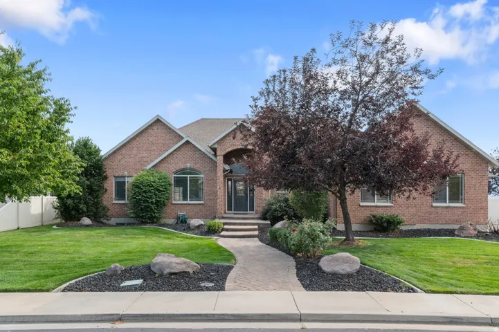 Brick exterior residence featuring a covered entry, arched window, and multiple rectangular windows