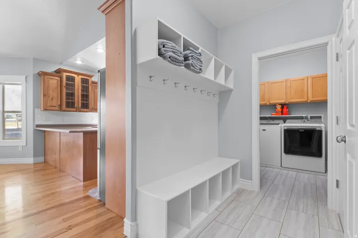 Entryway featuring a built-in bench with cubbies, overhead shelving, and coat hooks