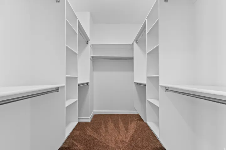 Custom closet system featuring white shelving and chrome hanging rods