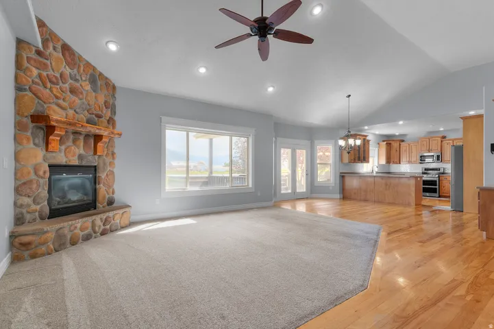 Great room with a stone-clad fireplace and wood mantle