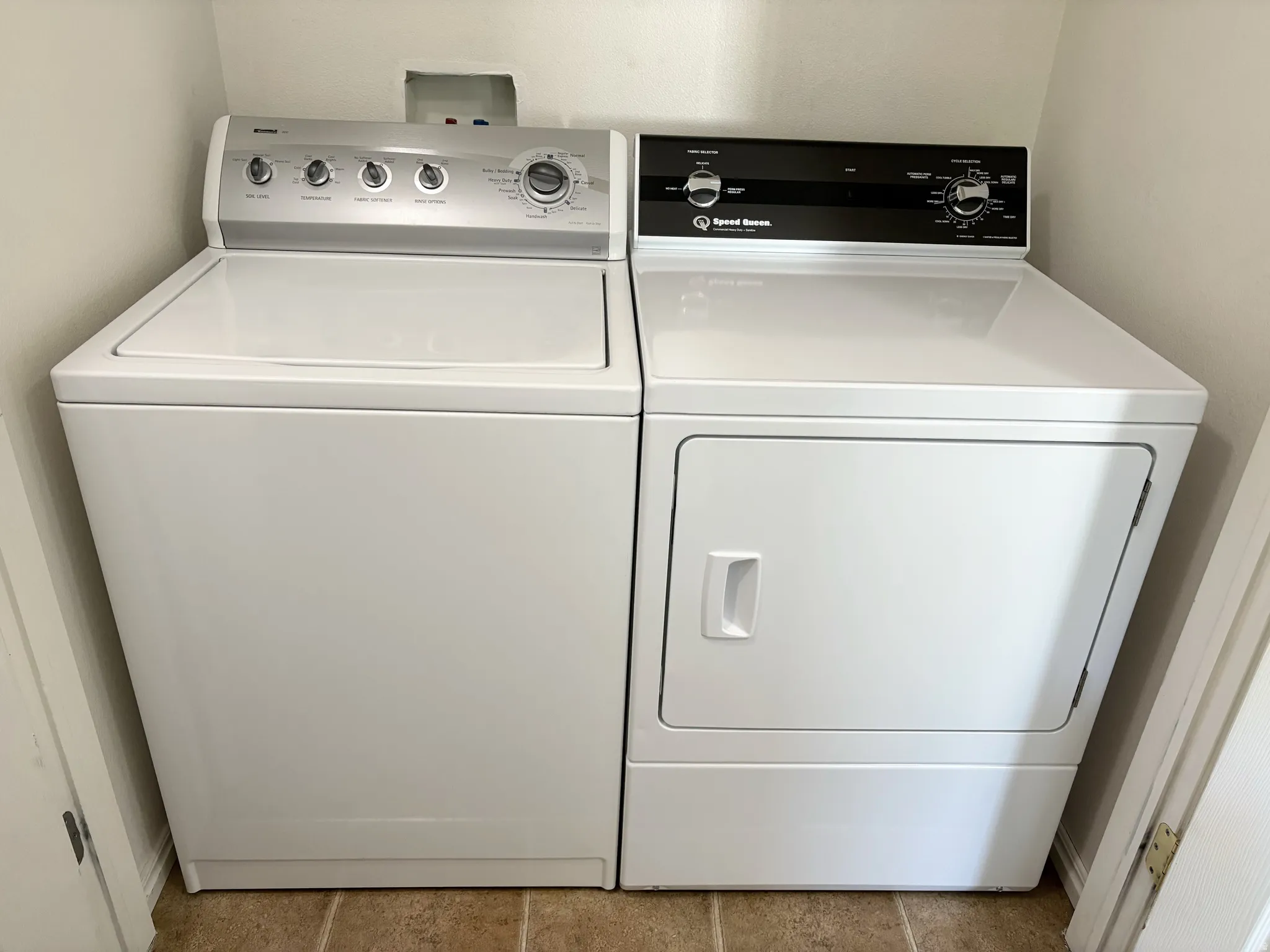 Dedicated laundry area featuring a white top-load washing machine and a white front-load dryer