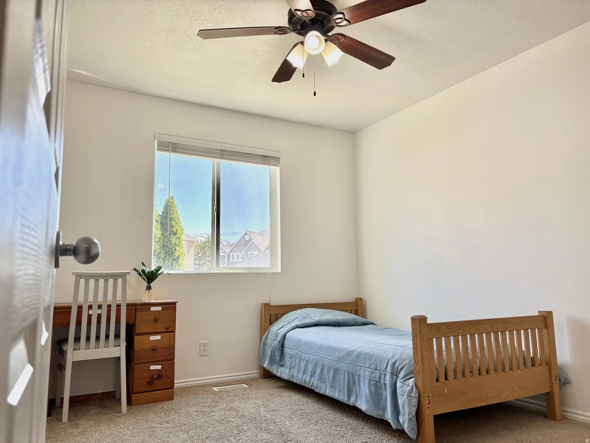 Carpeted room featuring a window with horizontal blinds, a ceiling fan with light fixture, and white painted walls