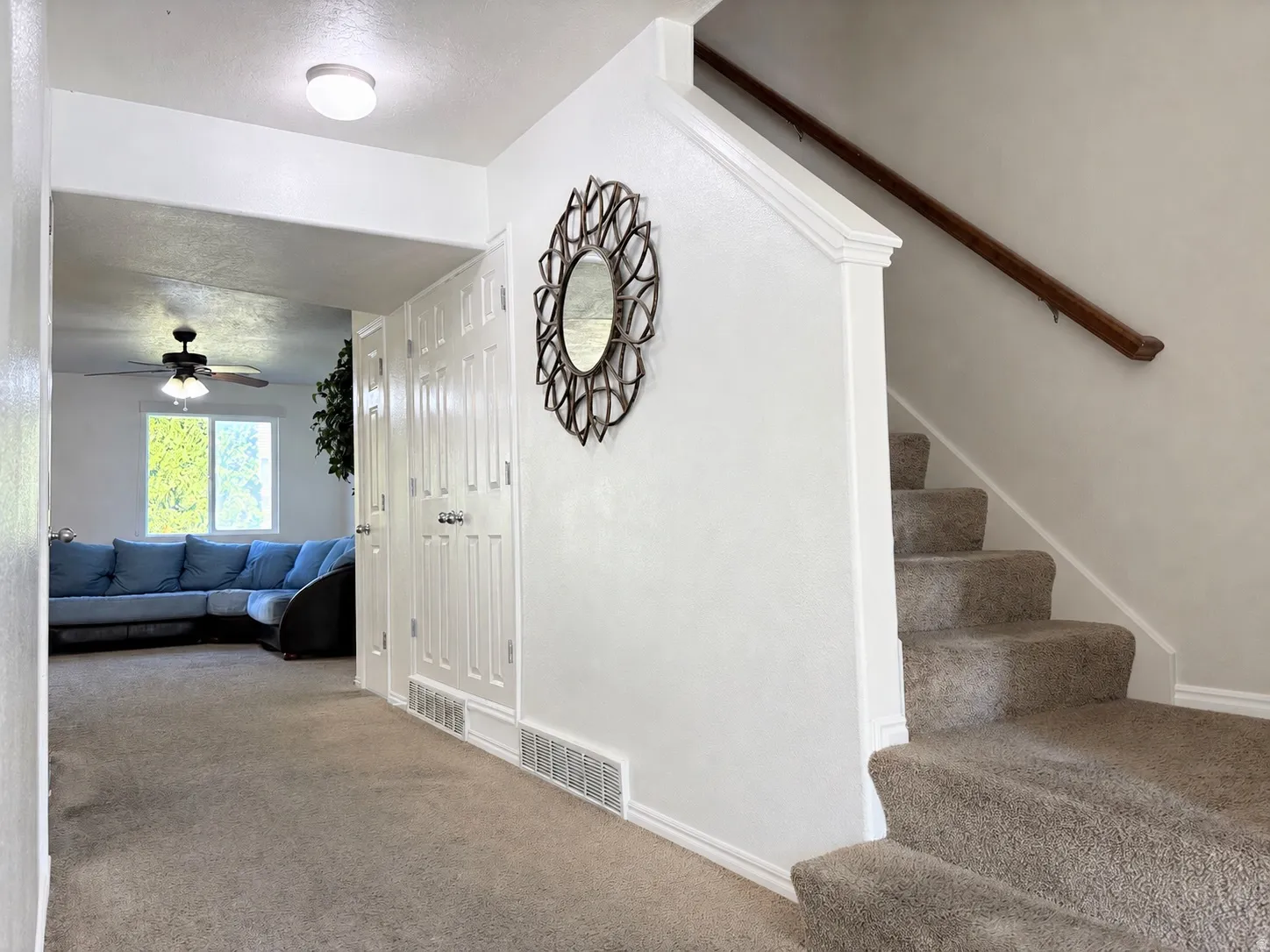 Carpeted staircase with a wood-finish handrail