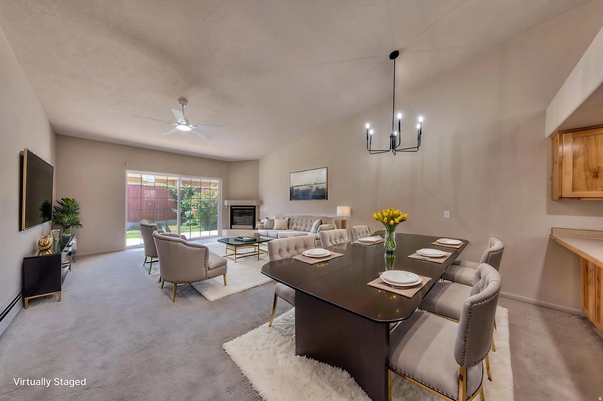 Vaulted ceilings elevate this open-concept living area with a fireplace and sliding glass doors