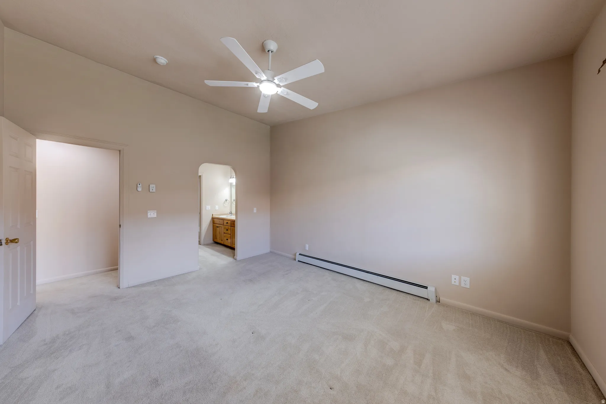 Spacious room with vaulted ceilings and a ceiling fan