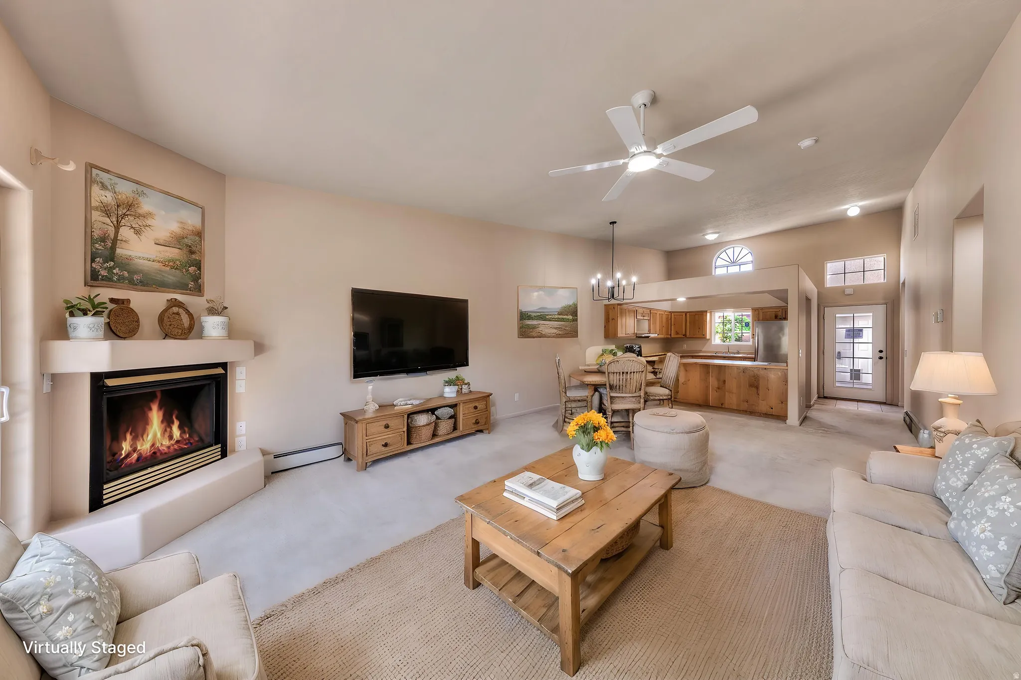 Spacious living area featuring a corner fireplace, vaulted ceilings, and a ceiling fan