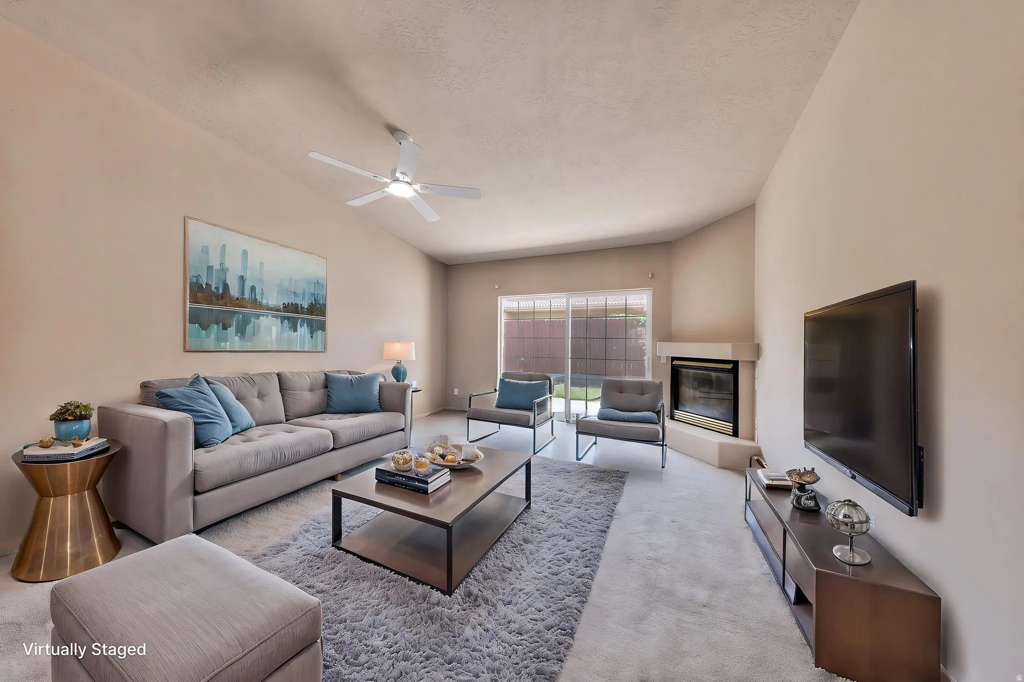 Living area featuring vaulted ceilings, a ceiling fan, plush carpet flooring, a corner fireplace, and sliding glass doors