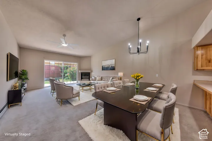 Vaulted ceilings elevate this open-concept living area with a fireplace and sliding glass doors