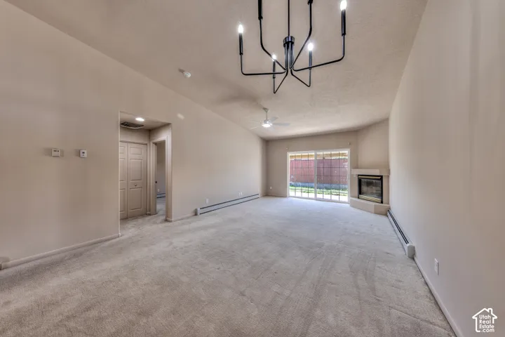 Spacious living area featuring neutral carpeting, a corner fireplace, and sliding glass doors to the exterior