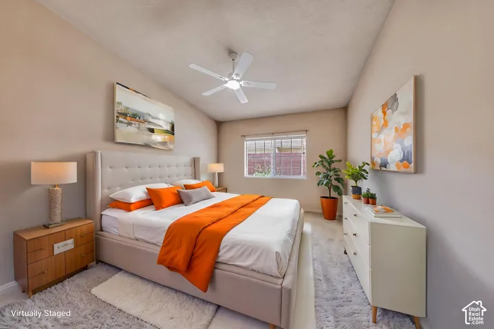 Spacious room featuring a vaulted ceiling and a ceiling fan