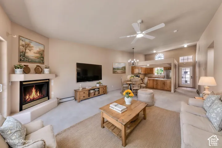 Spacious living area featuring a corner fireplace, vaulted ceilings, and a ceiling fan