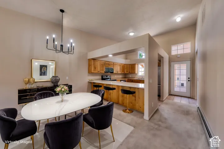 Dining area featuring a vaulted ceiling and a black chandelier