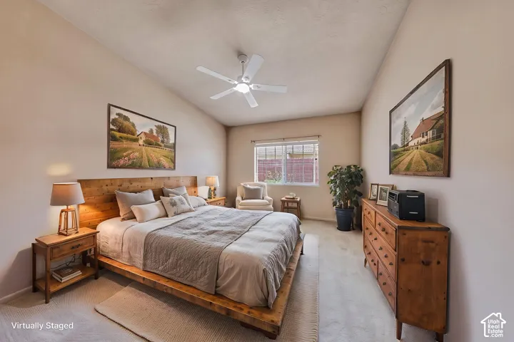 Spacious bedroom featuring vaulted ceilings, a ceiling fan, and carpet flooring