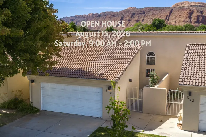 Stucco exterior featuring a tiled roof, arched window, and attached garage with concrete driveway
