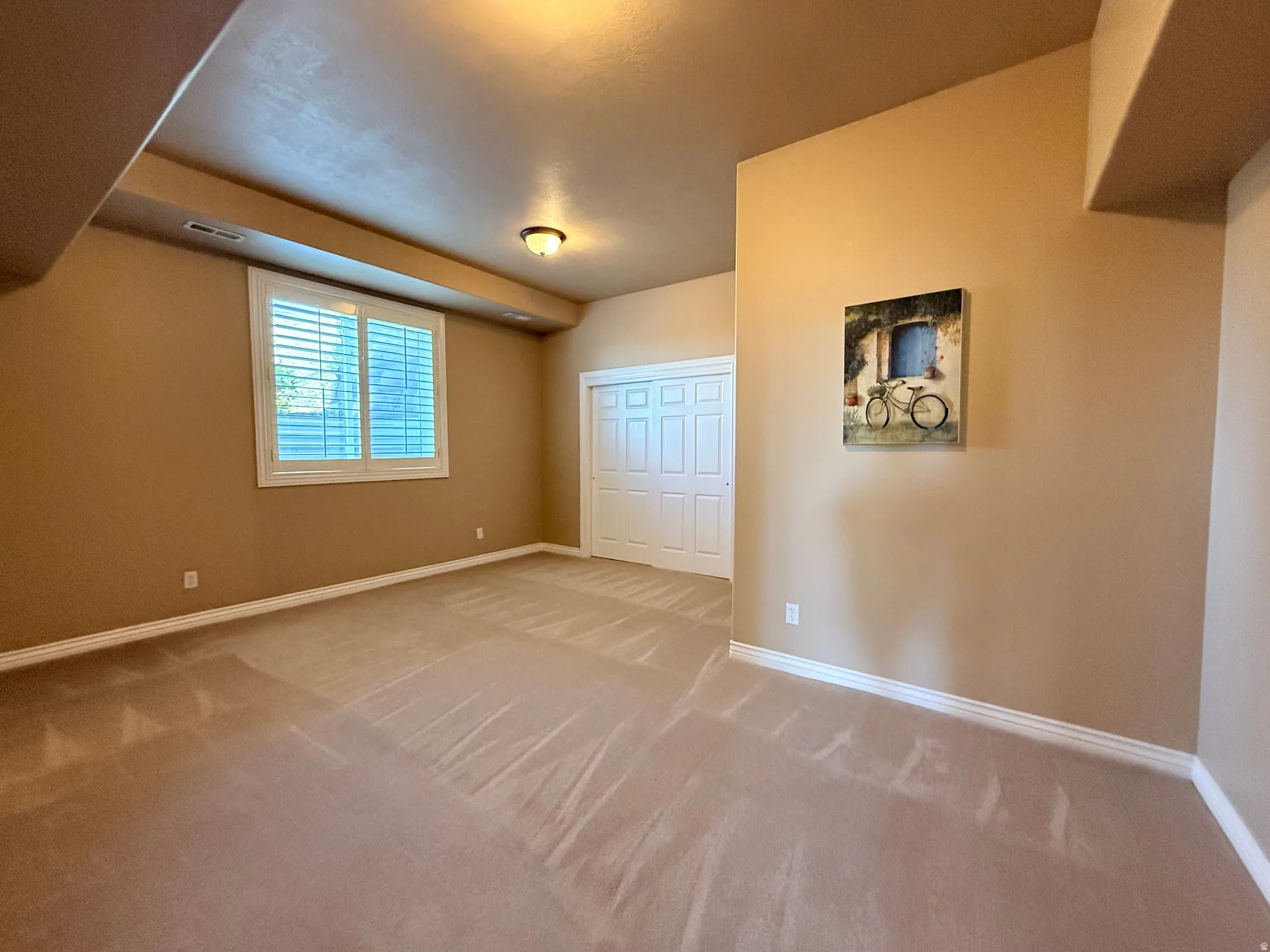 Room featuring neutral-toned walls, white baseboards, and wall-to-wall carpeting