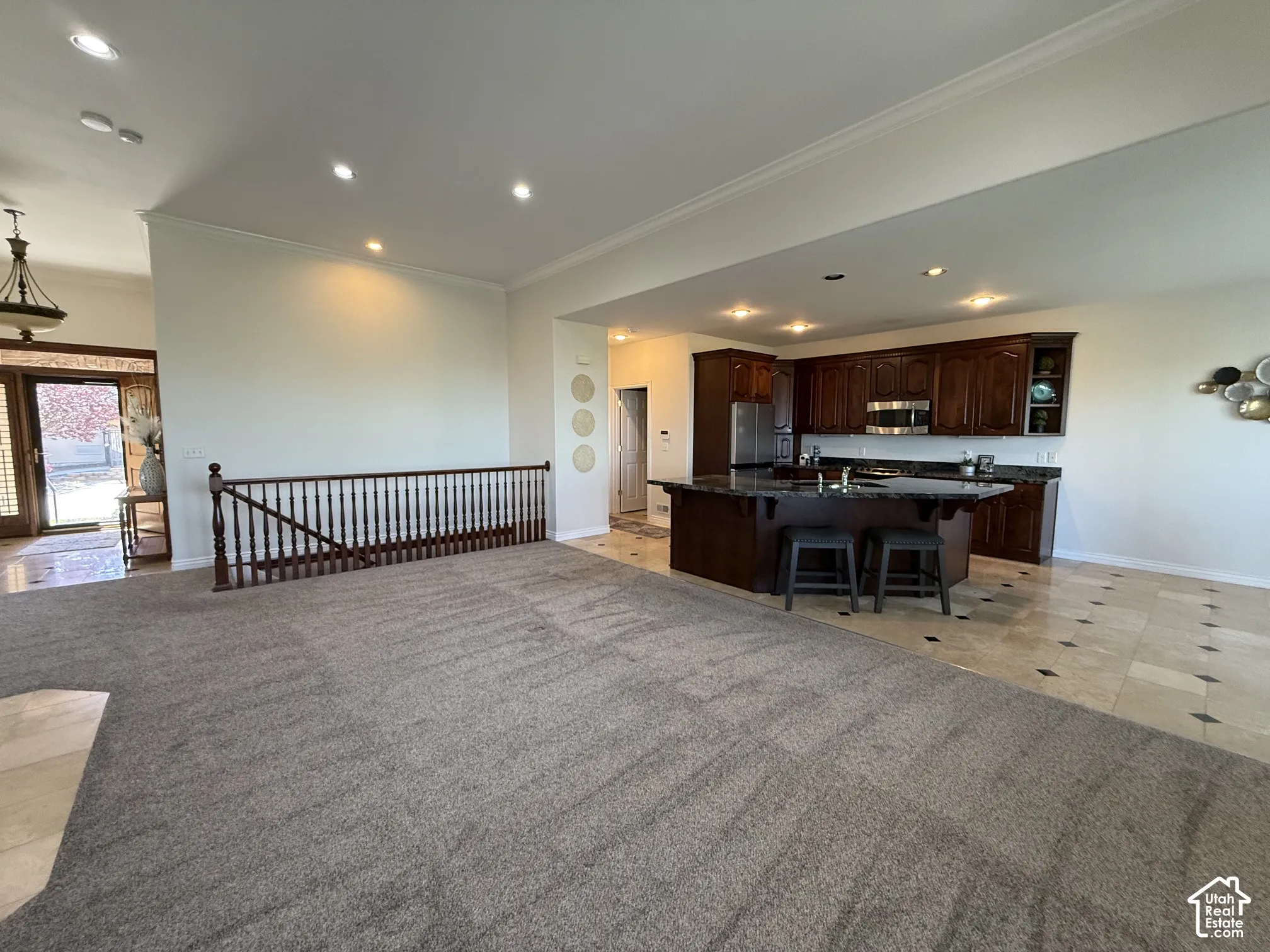 Open concept main living area featuring a kitchen with dark wood cabinetry and a dark stone-finish island