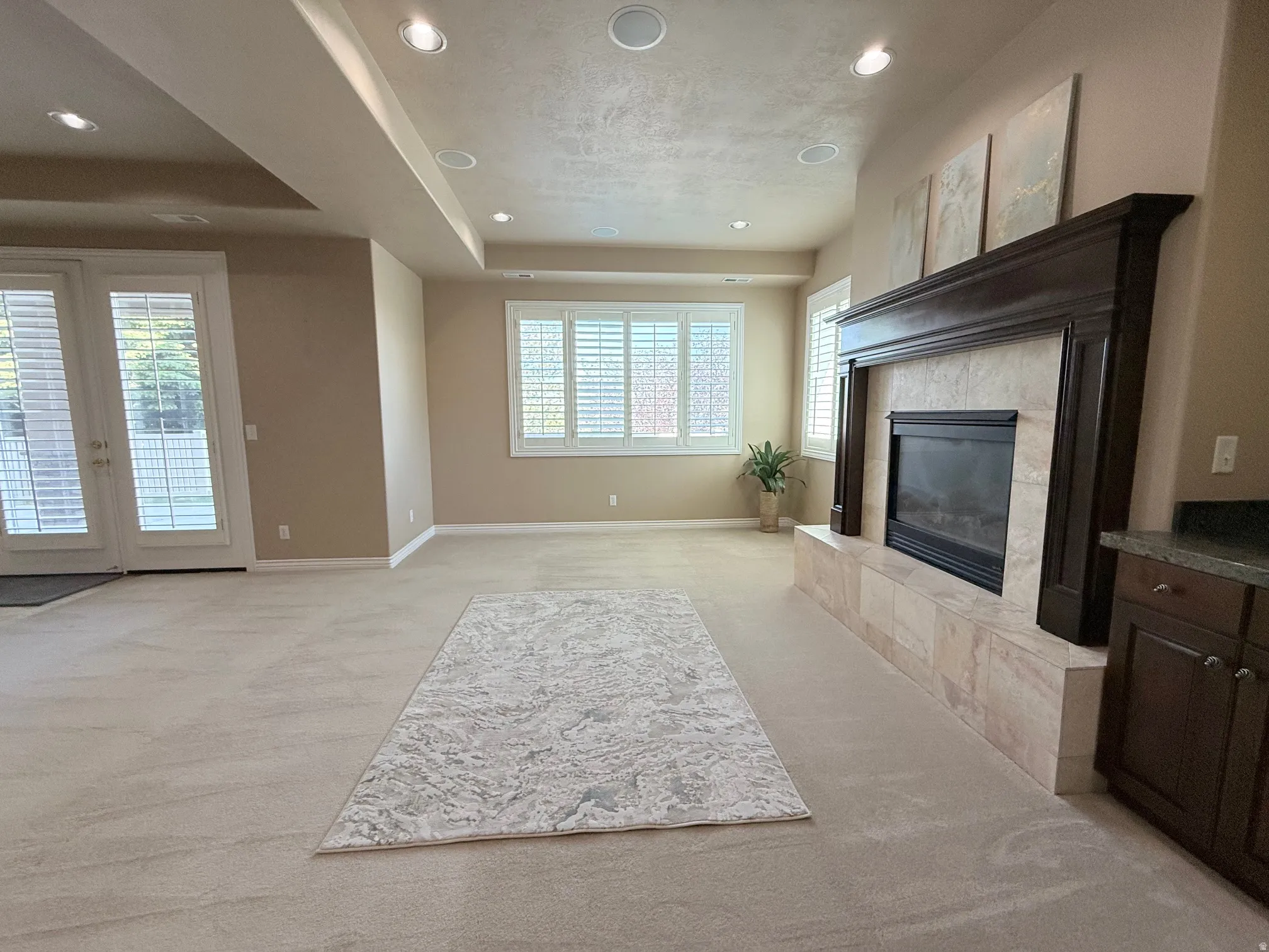 Spacious living area featuring a built-in fireplace with a dark wood mantle and a tile surround