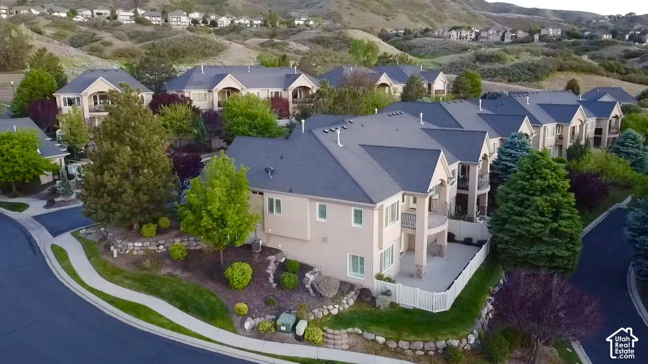Expansive property featuring a multi-level structure with a stucco exterior, a dark shingle roof, and multiple balconies