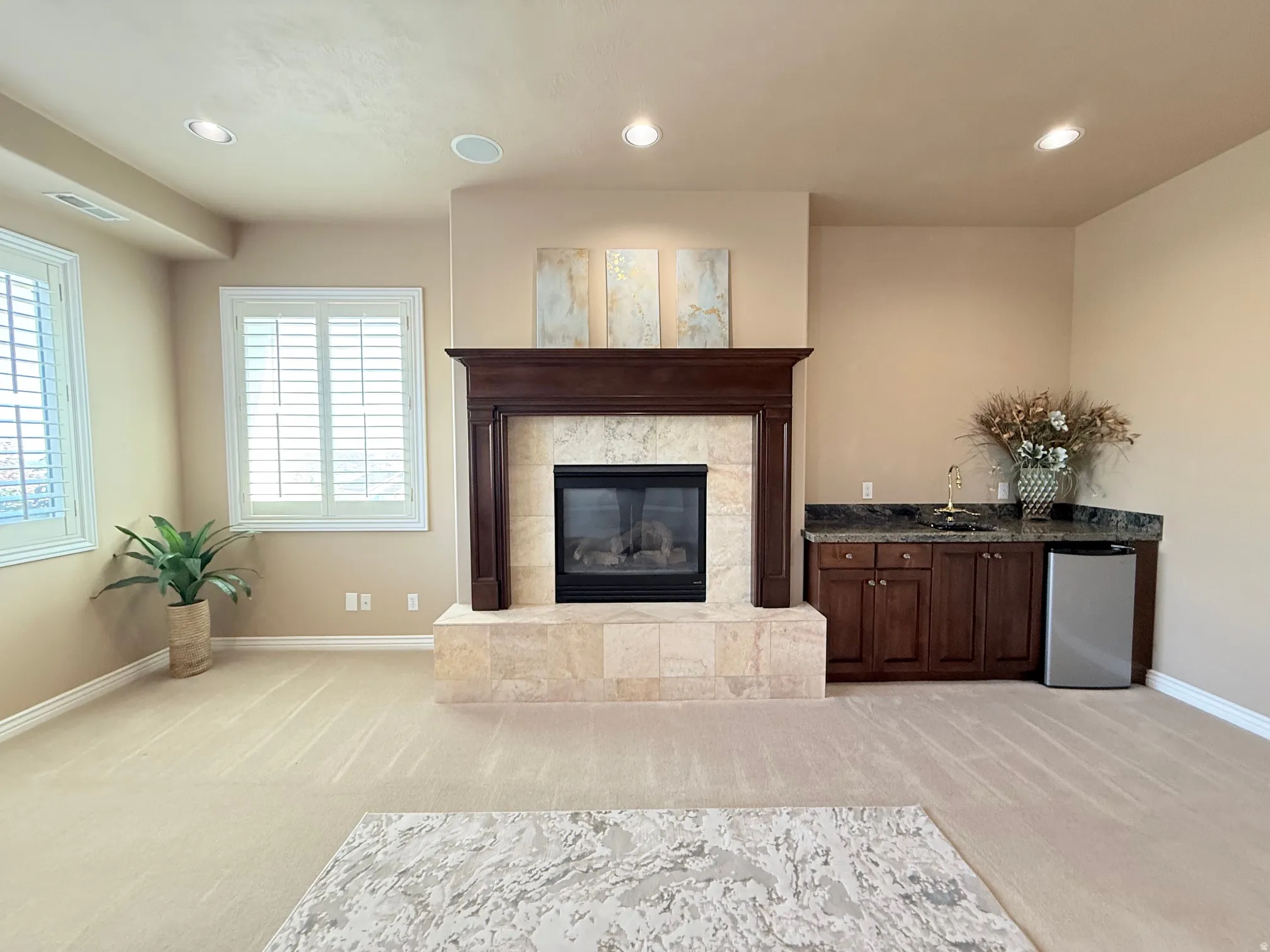 Living area featuring a gas fireplace with a stone surround and dark wood mantel