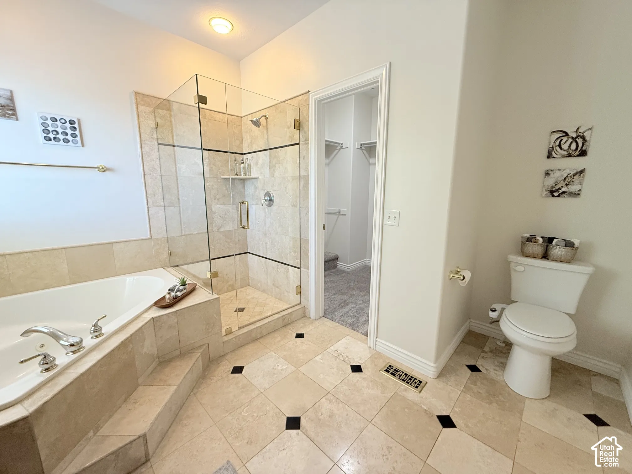 Spacious bathroom featuring a glass-enclosed walk-in shower with tile surround, a built-in soaking tub with tiled steps, and patterned tile flooring