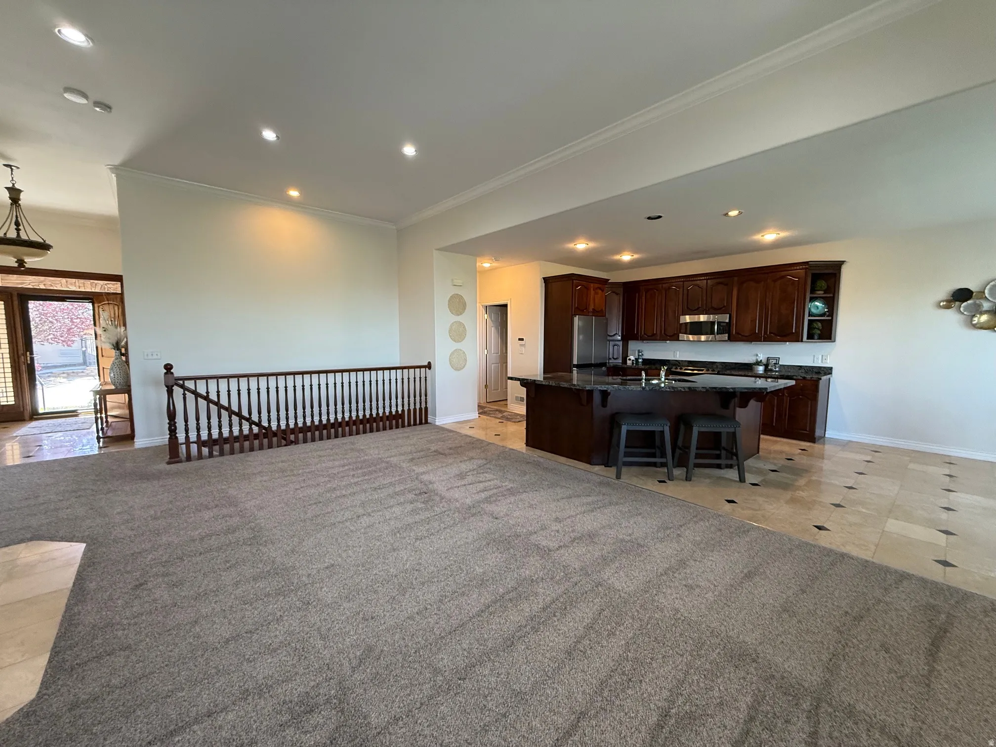 Open concept main living area featuring a kitchen with dark wood cabinetry and a dark stone-finish island