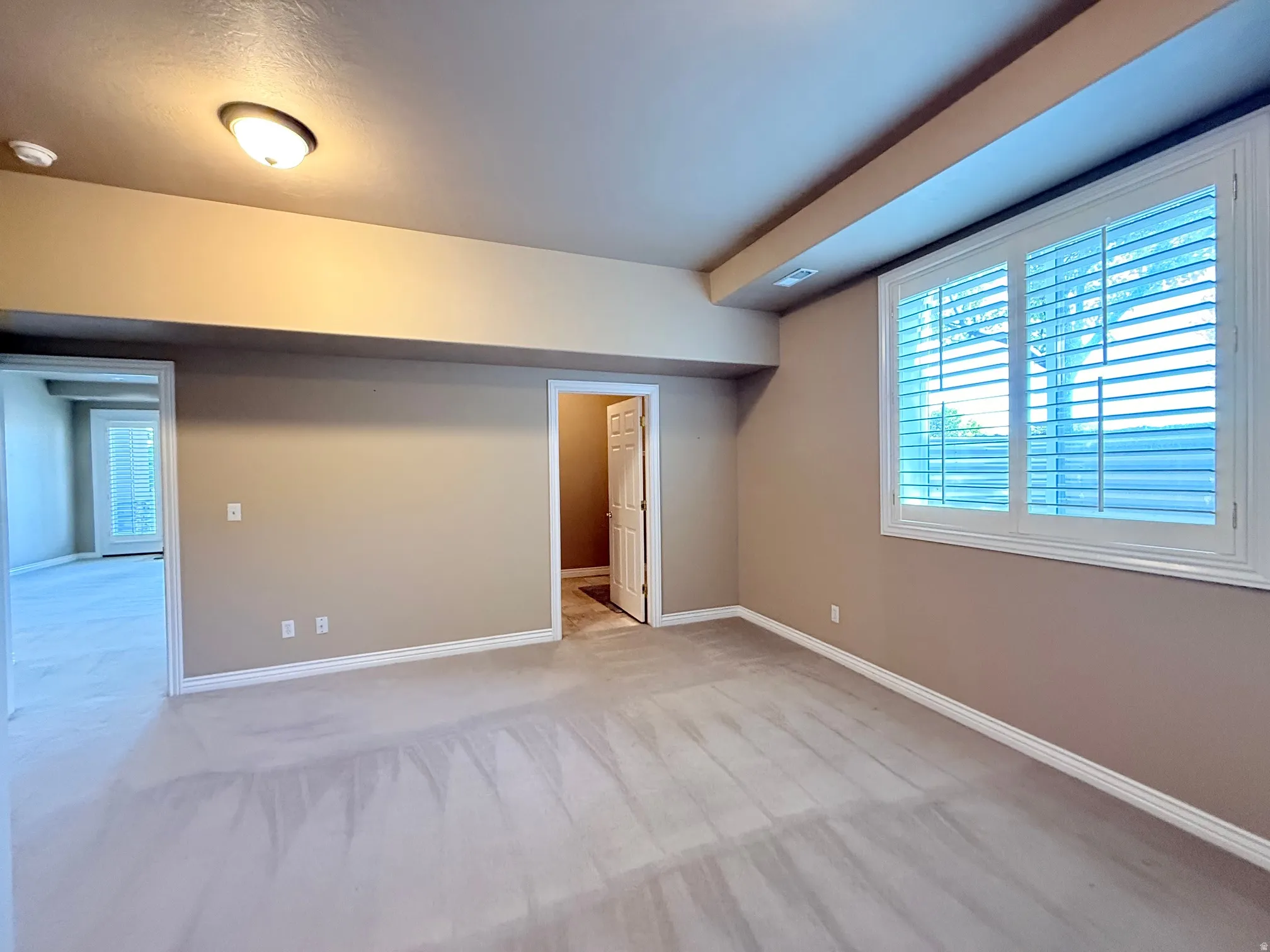Neutral-toned wall paint and light-colored carpet flooring define this interior space