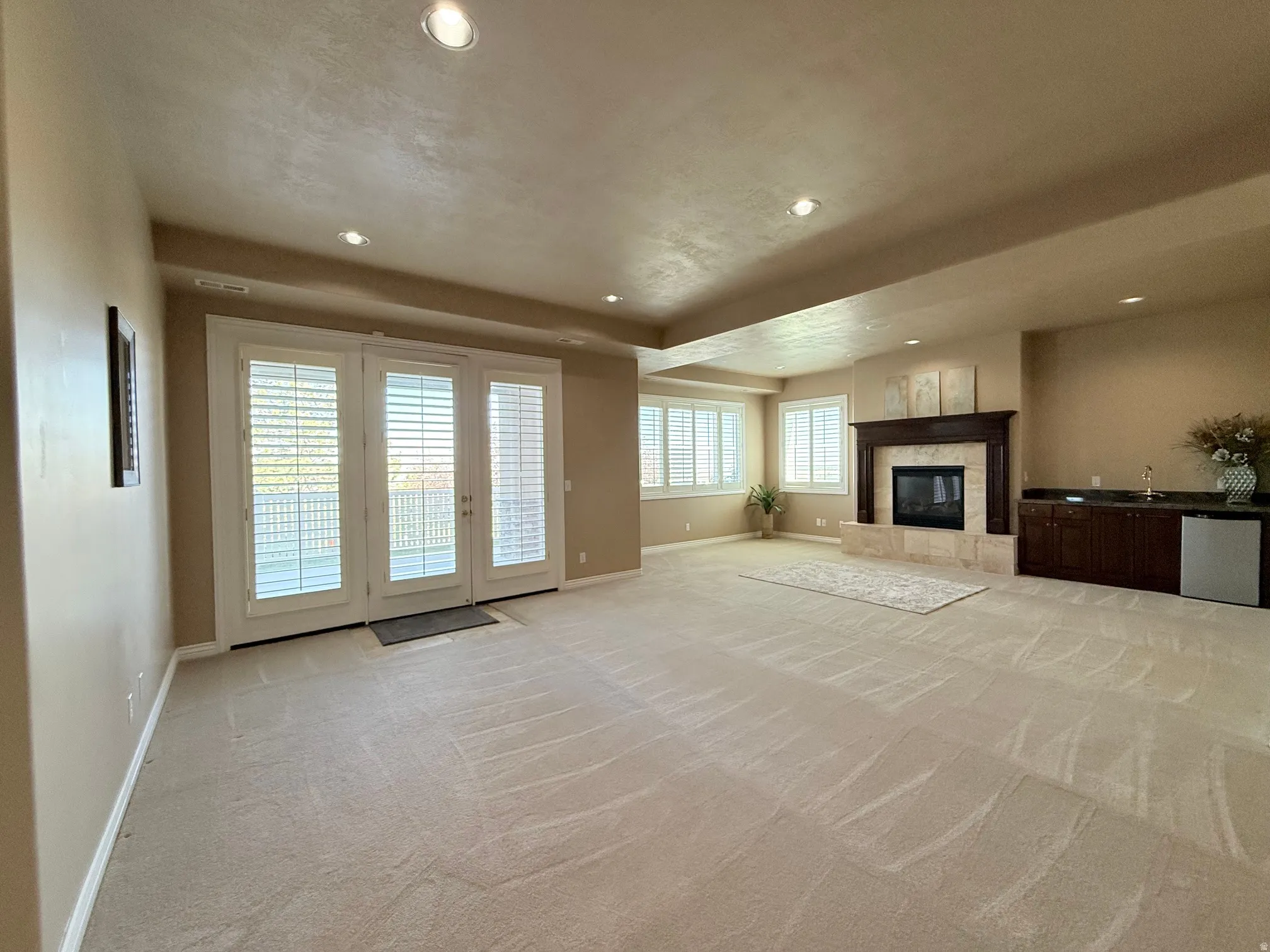 Spacious room featuring light-toned carpeting and recessed lighting