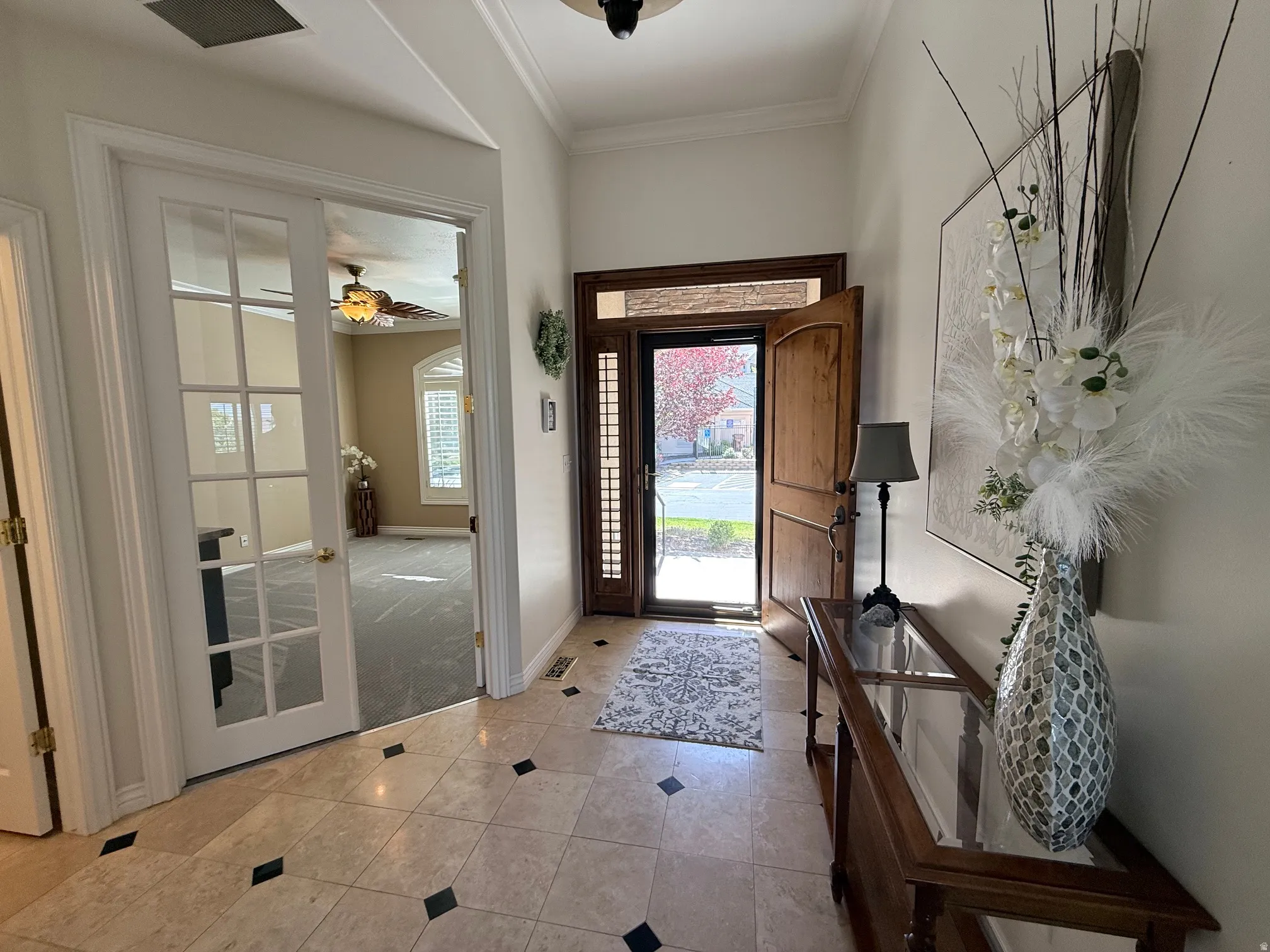 Entryway featuring light-toned tile flooring with dark accent squares