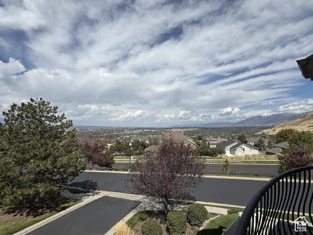 Expansive territorial scenery featuring distant mountains and a residential landscape