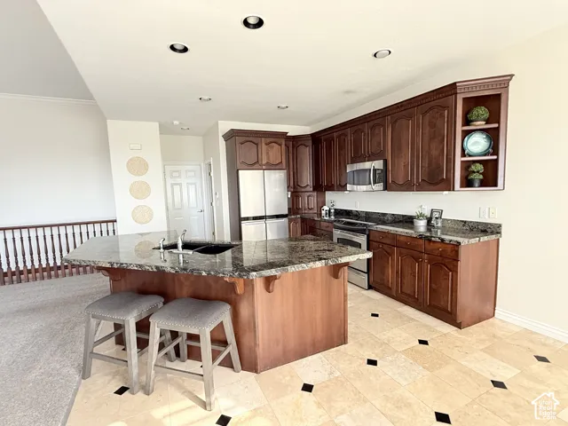 Kitchen featuring granite countertops, wood cabinetry, and stainless steel appliances